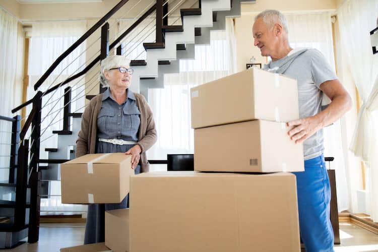 Senior couple packing boxes while downsizing home.