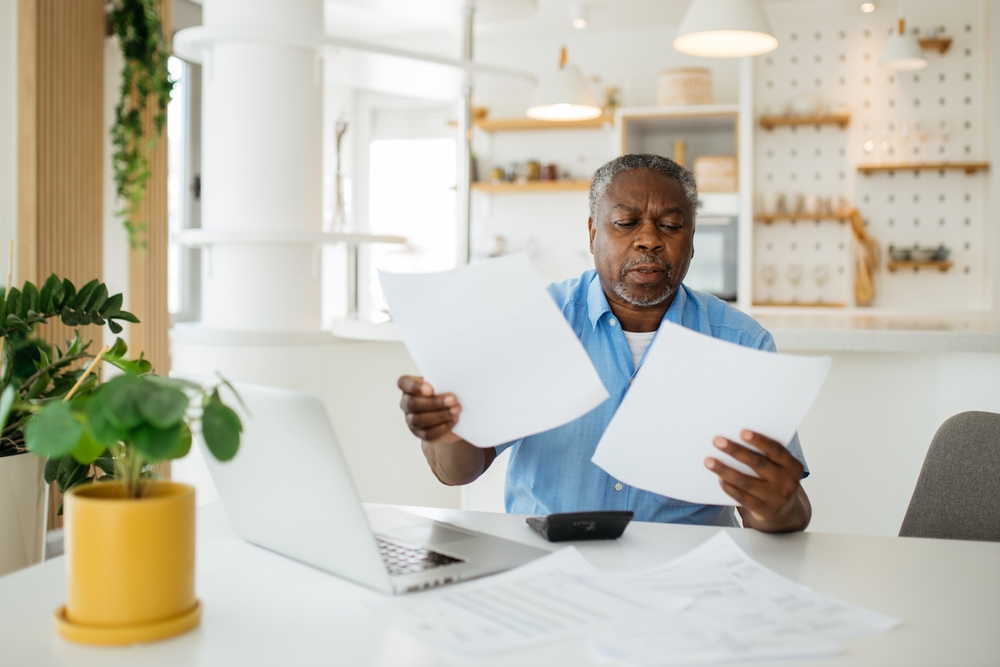 A senior man looks at paperwork