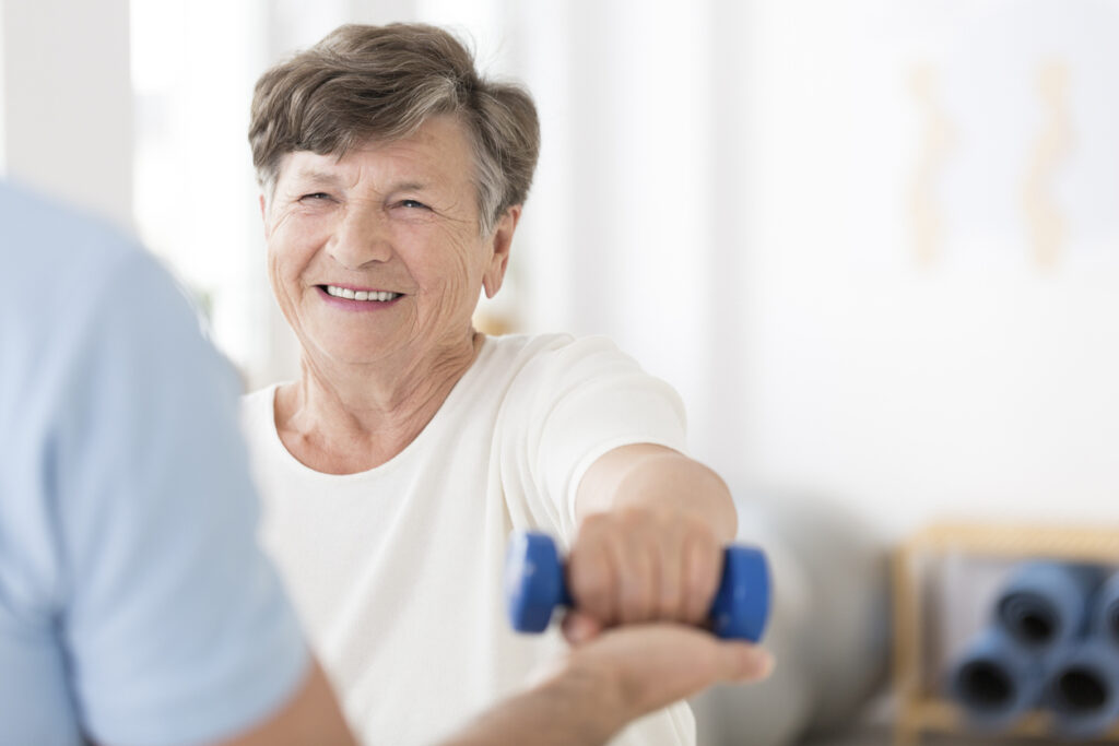 Senior Woman Smiling while Lifting Light Weight